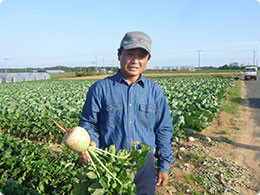 紅芯大根を持つ佐原さん。