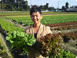 元気に育った野菜を持つ深川さん